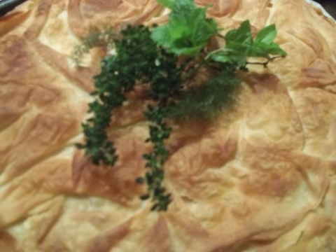 The pie is garnished with fresh herb to serve.